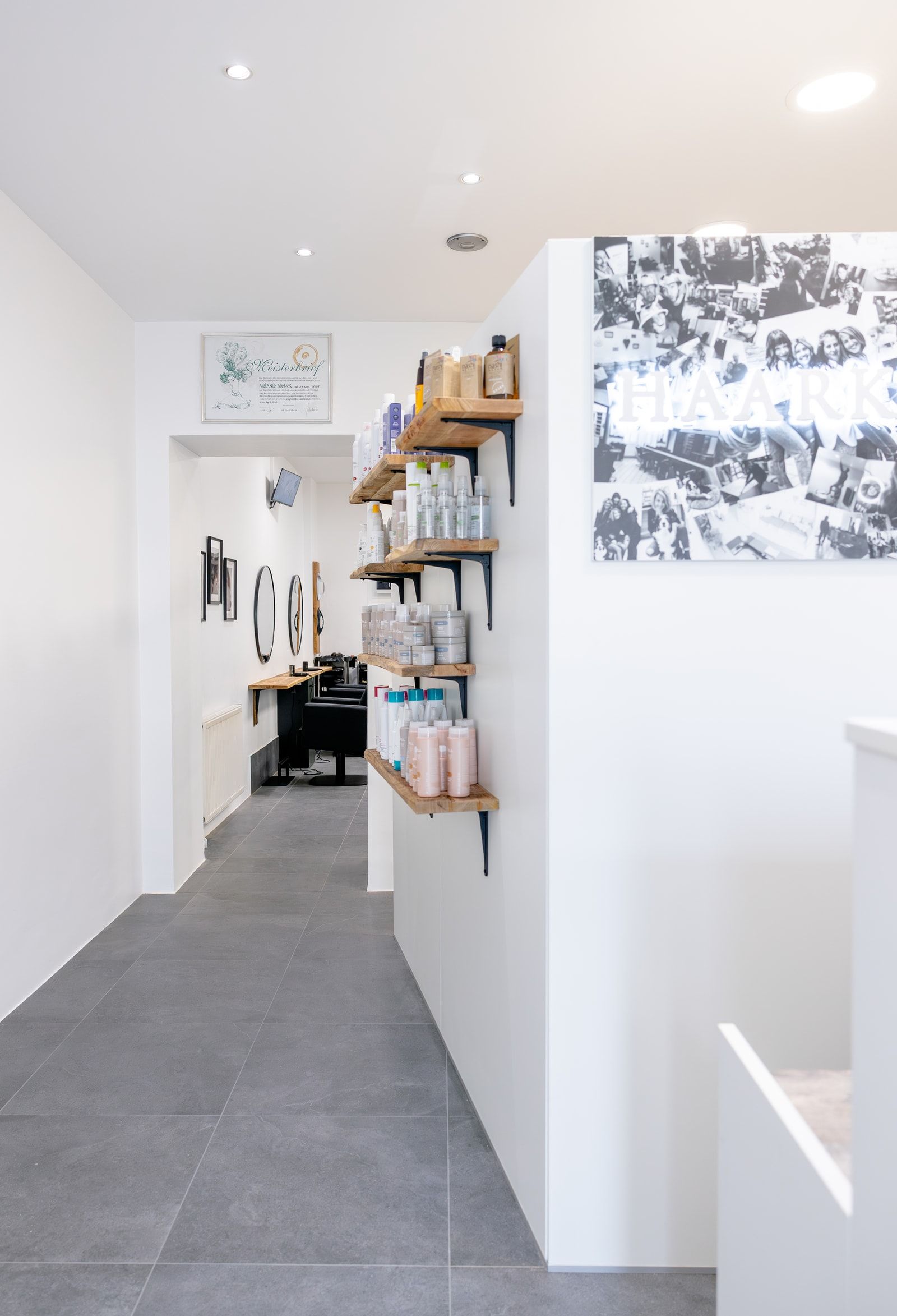 Heller Eingangsbereich des HAARKUNSTWERK Salons mit Produktregalen