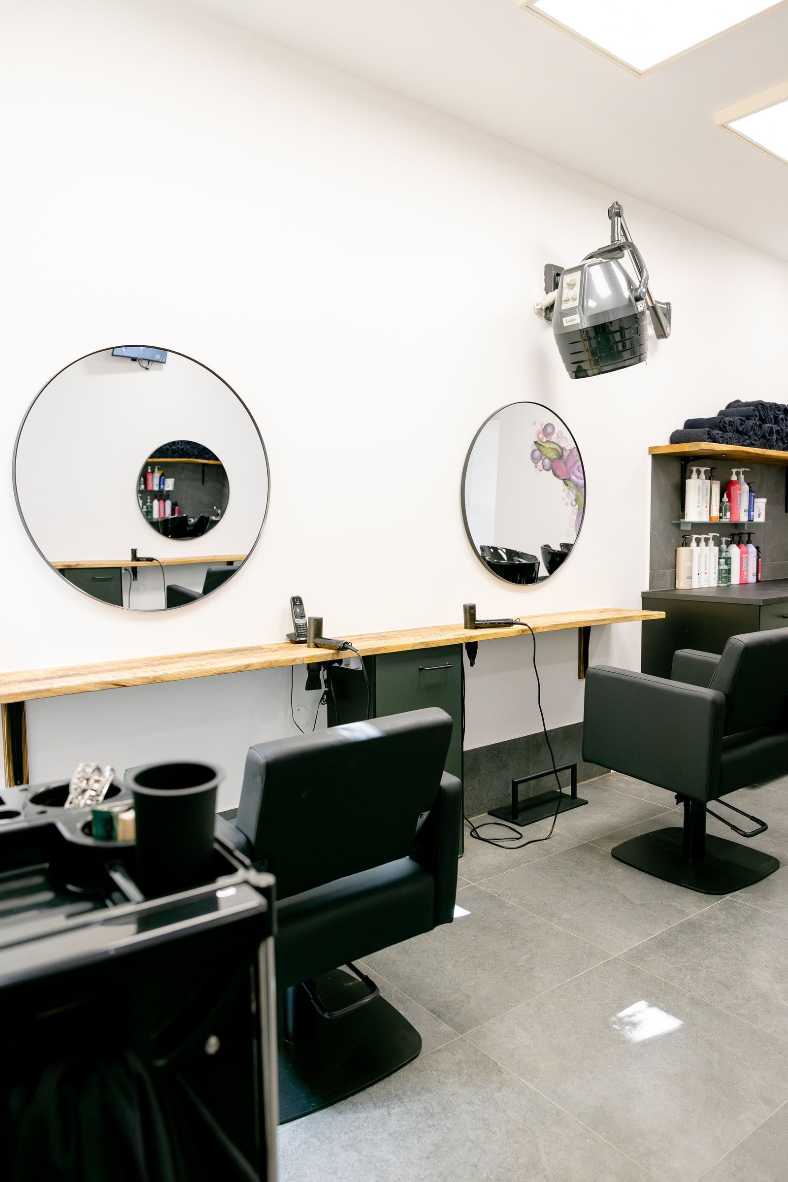 Großzügiger Stylingbereich mit Spiegeln, Sesseln und professionellen Pflegeprodukten
