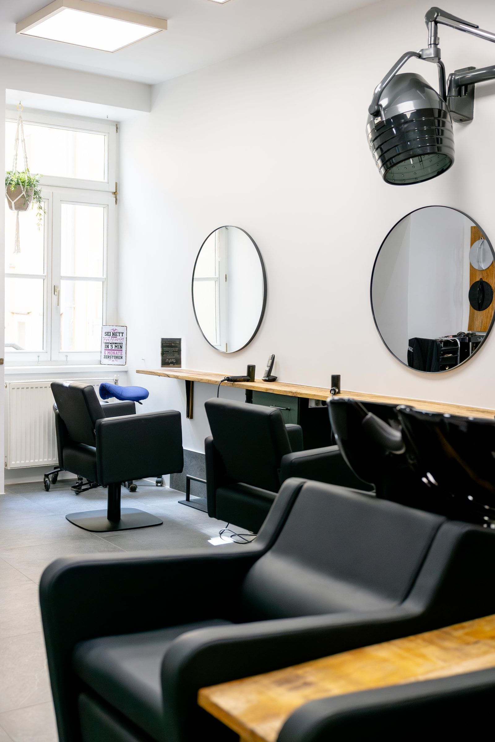 Heller Wasch- und Frisierbereich mit schwarzen Salonsesseln